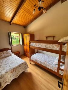 a bedroom with two bunk beds and a wooden ceiling at Apartamentos El Campal in Felechosa