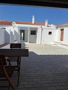 a wooden bench sitting on a patio in front of a house at Casa Grande do Monte in Mértola