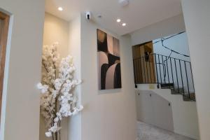 a hallway with white walls and a vase of flowers at La Maison Solférino in Boulogne-Billancourt