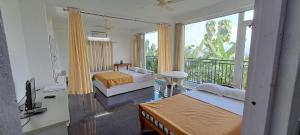 a bedroom with two beds and a balcony at Mist Farm Resort in Avanāshi