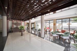 a lobby with tables and chairs in a building at Duyên Hùng Premier Hotel in Diện Biên Phủ