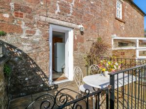 a brick building with a table on a balcony at The Old Coach House in Lockerbie