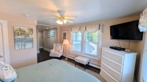 a bedroom with a bed and a flat screen tv at The Hewitt Wellington Hotel in Spring Lake