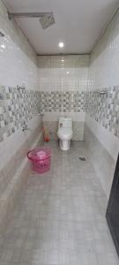 a bathroom with a toilet and a pink tub at Mist Farm Resort in Avanāshi