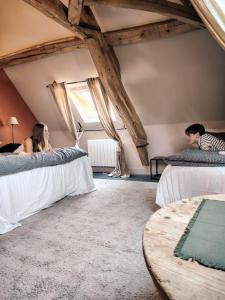a group of people sitting on beds in a room at Le Paddock - Chambres et table d'hôtes in Le Déluge +87 photos