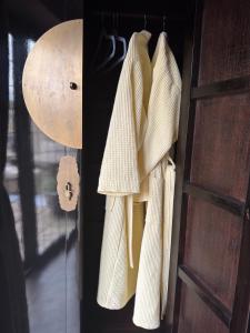 a pair of white sweaters hanging on a door at Balancyoga Guesthouse in Ash