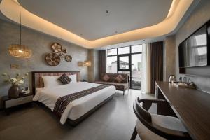 a bedroom with a bed and a desk and a couch at Duyên Hùng Premier Hotel in Diện Biên Phủ +41 photos