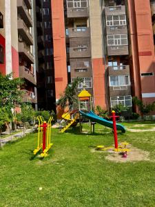 a playground in front of a tall apartment building at ZenRoofs - Brij Bhumi Haven 1 in Vrindāvan