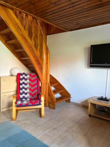 a living room with a chair and a tv at First Tee am Rosarium in Sangerhausen
