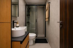 a bathroom with a toilet and a sink and a shower at Allure Suites in Larnaca +10 photos