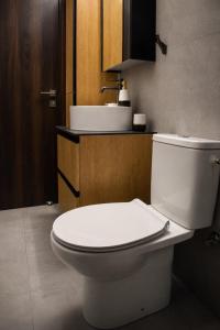 a bathroom with a white toilet and a sink at Allure Suites in Larnaca