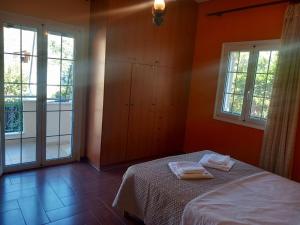 a bedroom with a bed and two windows at Mytikas villa in Kandíla