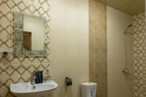 a bathroom with a sink and a mirror and a toilet at Old House Residence Aghveran & Restaurant in Arzakan