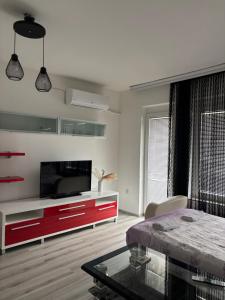 a living room with a television and a red cabinet at Apartment ANGELA Ohrid in Ohrid