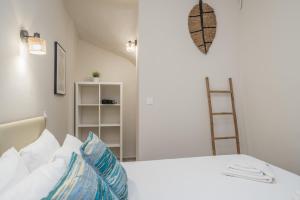 a bedroom with a white bed with blue and white pillows at Tassos Cottage Fiskardo in Fiskardo