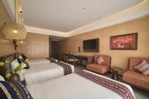 a hotel room with two beds and a television at Duyên Hùng Premier Hotel in Diện Biên Phủ