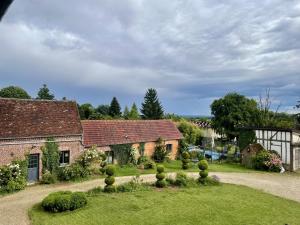 an old house with a garden in front of it at Le Paddock - Chambres et table d'hôtes in Le Déluge