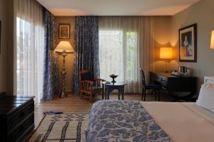 a hotel room with a bed and a desk and a window at La Villa Mandarine in Rabat +139 photos