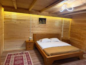 a bedroom with a bed in a wooden room at Valbone Two E in Valbonë +9 photos