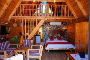 a bedroom with a bed and chairs in a room at Doğallife suit bungalow in Çamlıhemşin
