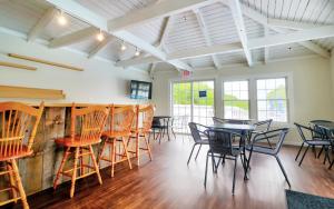 a dining room with tables and chairs and windows at Ogunquit Tides in Ogunquit