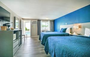 a bedroom with two beds and a blue wall at Ogunquit Tides in Ogunquit +87 photos