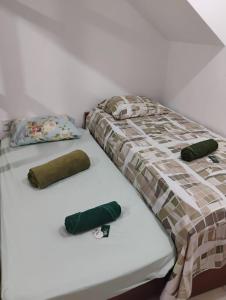 a bed with two green pillows on it at Casa Tia Celinha e Cafeteria in Teresópolis