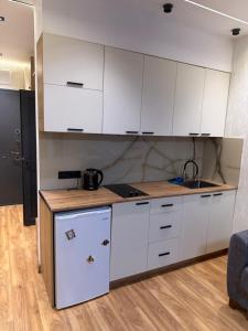 a kitchen with white cabinets and a counter top at Fantastico 270 in Batumi