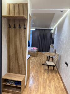 a room with a table and chairs and a bedroom at Fantastico 270 in Batumi