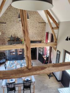 a room with a table and chairs and a brick wall at Le Paddock - Chambres et table d'hôtes in Le Déluge
