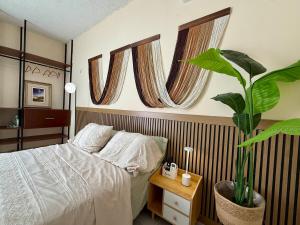 a bedroom with a bed and a potted plant at Kinara merida yucatan con alberca y jacuzzi privado in Mérida +105 photos