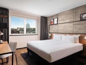 a hotel room with a large bed and a window at ibis London Earls Court in London