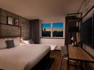 a hotel room with a large bed and a window at ibis London Earls Court in London