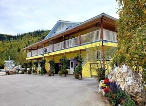 a yellow building with a balcony on top of it at Bonanza Gold Motel in Dawson City