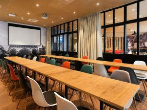 a conference room with wooden tables and chairs at Hotel ibis Dijon Centre Clemenceau in Dijon