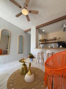 a living room with a ceiling fan and a table at Kinara merida yucatan con alberca y jacuzzi privado in Mérida