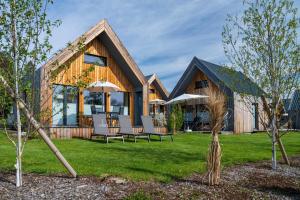 a home with a wooden house with a lawn at Schmids Ferienoase in Ostrach
