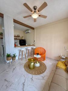a living room with a couch and a ceiling fan at Kinara merida yucatan con alberca y jacuzzi privado in Mérida
