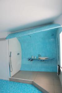a blue bathroom with a shower and a sink at L'inattendu in Les Piards