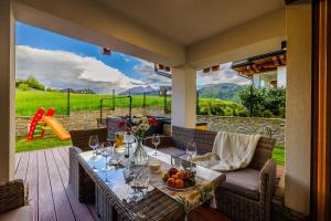 a table with wine glasses on a patio at Rogata Chata Tatra View & Jacuzzi in Kościelisko