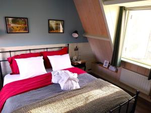 a bedroom with a bed with red and white sheets at Het Vissershuisje in Edam