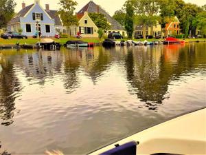a boat in the water in front of houses at Het Vissershuisje in Edam