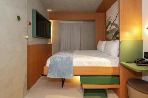 a small room with a bed and a desk at Motto By Hilton Recife in Recife