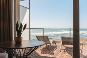 a room with a table and chairs and the ocean at Hotel Flor De Sal by The Editory in Viana do Castelo
