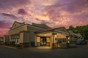 a building with a car parked in a parking lot at Red Roof Inn Gastonia in Gastonia