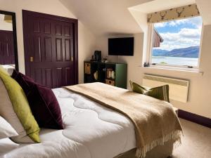 a bedroom with a bed and a large window at Ardvreck House in Ullapool
