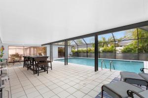 a house with a pool and a table and chairs at Naples Luxury 5BDRM HomeHtd PoolSuperCleanPets in Naples