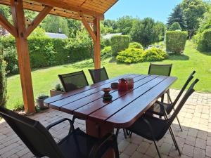 a wooden table and chairs on a patio at Boglárka Vendégház in Vasvár