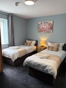 a bedroom with two beds with a lamp and a window at The Pod on John St in Wexford