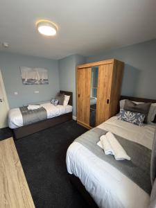 a bedroom with two beds and a wooden cabinet at The Pod on John St in Wexford